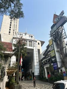 a man walking down a street in front of a building at Apartment 3BR Prima Bragacitywalk in Bandung