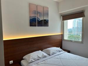 a bedroom with a bed and a window at Apartment 3BR Prima Bragacitywalk in Bandung