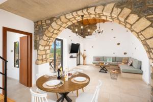 a living room with a table and a stone wall at La Casa Di Pietre 1 in Kiotari