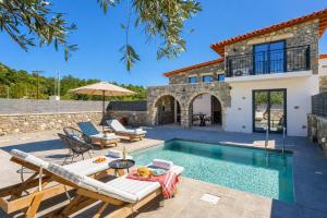 a villa with a swimming pool and a house at La Casa Di Pietre 1 in Kiotari