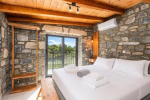a bedroom with a large white bed in a stone wall at La Casa Di Pietre 1 in Kiotari +10 photos