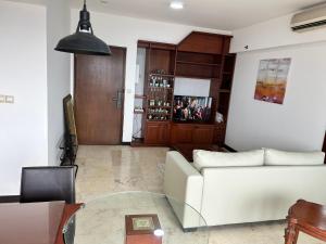 a living room with a white couch and a glass table at Apartment 3BR Prima Bragacitywalk in Bandung +4 photos