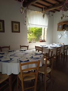 a dining room with white tables and chairs and a window at Agriturismo Abbonbri in Quarrata