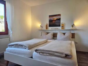 two beds in a room with towels on them at Auszeit an der Eider in Hennstedt