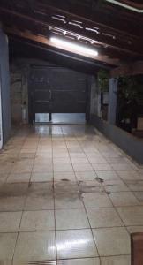 an empty garage with a door and a tiled floor at Pensão por do sol in Ribeirão Preto