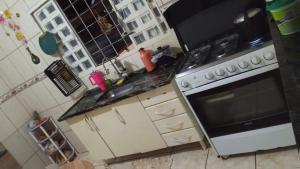 a kitchen with a stove and a sink at Pensão por do sol in Ribeirão Preto