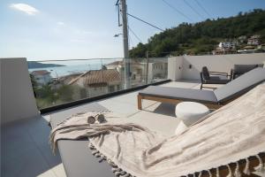 a balcony with a bed and a view of the ocean at ŌMNIMI Signature Living in Skala Potamias