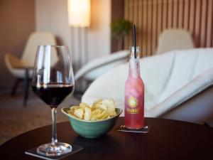 a glass of wine and a bowl of chips on a table at B&B HOTEL Fürth-Hardhöhe in Fürth