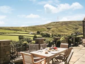 a wooden table and chairs on a patio with a view at Mount View - Uk48425 in Holmfirth