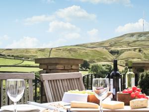 a table with wine bottles and cheese and wine glasses at Mount View - Uk48425 in Holmfirth +15 photos