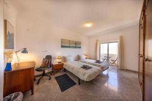 a bedroom with a bed and a desk and a chair at Local Guesthouse in Sagres