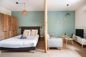 a bedroom with a bed and a chair at Vina Rhona - Loft de charme entre Rhône et Vignes climatisé in Condrieu