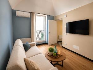 a living room with a couch and a flat screen tv at Cà di Righe in Pietra Ligure