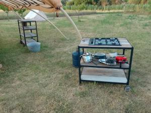 a table with a gas stove in a field at Tente Cocoon in La Brillanne