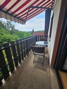 a patio with a table and chairs on a balcony at FeWo Zimmer Waldmohr in Waldmohr