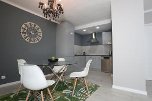 a dining room with a table and chairs and a clock at Villa Bocage in Setúbal