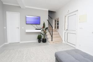 a white room with a tv on a wall at Villa Bocage in Setúbal