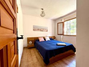 a bedroom with a blue bed and a window at Villa Sa Guaita in Sant Josep de sa Talaia +32 photos