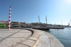 a boat is docked at a marina with a lighthouse at Villa Bocage in Setúbal