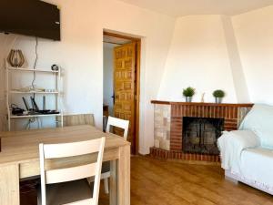 a living room with a table and a fireplace at Villa Sa Guaita in Sant Josep de sa Talaia