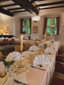 a large banquet hall with white tables and chairs at Schlosshotel am Hainich in Hörselberg-Hainich