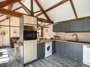 a kitchen with gray cabinets and a washer and dryer at Cart House Barn - Uk49802 in Morville