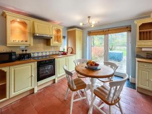 a kitchen with a table and chairs in a room at Y Ddol in Llansannan