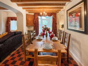 a dining room with a table and a couch at Y Ddol in Llansannan