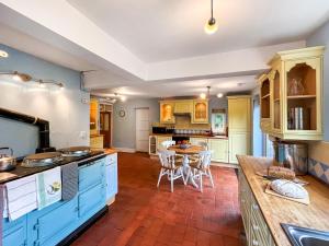 a kitchen with blue cabinets and a table at Y Ddol in Llansannan