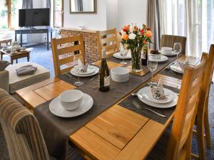 a dining room table with plates and wine glasses at Dippers in Smallburgh