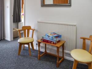 a room with two chairs and a table with books on it at Dippers in Smallburgh +19 photos
