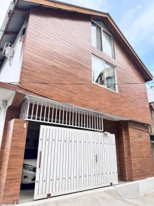a brick house with a white garage door at Daisy Cottage in Murree