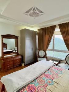 a bedroom with a large bed and a large mirror at Daisy Cottage in Murree