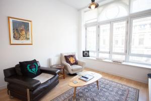 a living room with a couch and a chair and a table at The Art Flat Glasgow in Glasgow