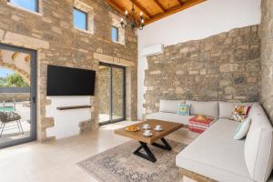 a living room with a stone wall at La Casa Di Pietre 3 in Kiotari
