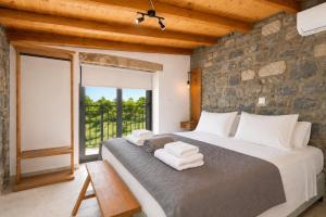 a bedroom with a large bed with towels on it at La Casa Di Pietre 3 in Kiotari +12 photos