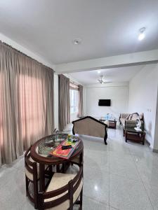 a living room with a table and a couch at Daisy Cottage in Murree