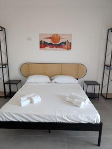 a bed with two white towels on top of it at The Essential - Reggia Di Caserta in Caserta