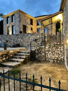 a stone house with a stone wall and stairs at Mesovouni Stone Suites 1 in Mesovounion-Zagori