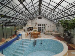a large pool in a living room with a glass ceiling at Casă de oaspeți autentică în Transilvania in Izvoru Mureşului