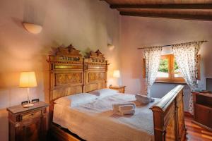 a bedroom with a large wooden bed and a window at Tenuta Bellingeri - Locanda del Barco in Sant' Agata fossili
