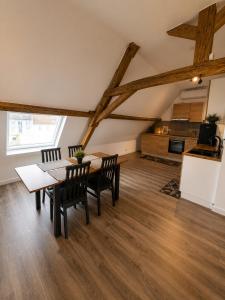 a dining room with a table and chairs and a kitchen at Les lodges d'Eva de Chièvres in Chièvres +12 photos