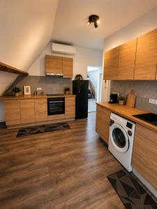 a kitchen with wooden cabinets and a washing machine at Les lodges d'Eva de Chièvres in Chièvres