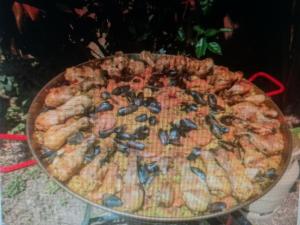a large pizza with mussels and shrimp on a table at Tente Cocoon in La Brillanne