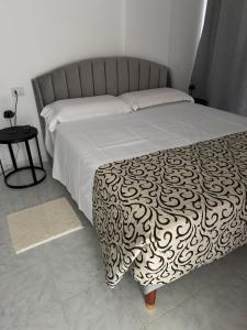 a bed with a black and white bedspread and a table at B&B BLESSED bilocale in Perugia