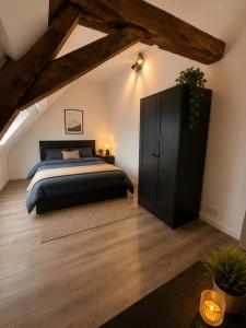 a bedroom with a bed and a black cabinet at Les lodges d'Eva de Chièvres in Chièvres