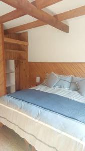 a bedroom with a large bed with wooden ceilings at MI Lodge Las Trancas Hotel & Spa in Las Trancas