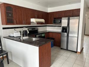 a kitchen with wooden cabinets and a stainless steel refrigerator at HomeNet in Toronto