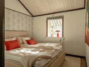 a bedroom with a bed with red pillows on it at Siljansnäs Stugby in Siljansnäs +257 photos