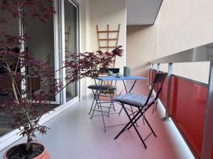 a balcony with a table and chairs and a plant at Eden-Novia in Orléans